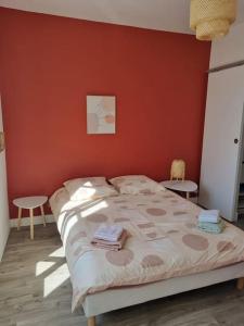- une chambre dotée d'un lit avec un mur rouge dans l'établissement Appartement au cœur d'Orléans en bord de Loire, à Orléans