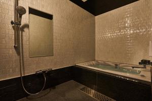 東京的住宿－M4 design hotel，带浴缸和镜子的浴室