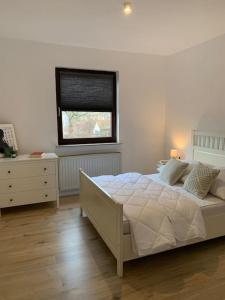 a bedroom with a white bed and a window at Stilvolle Wohnung mit Balkon & Parkplätzen in Bremen