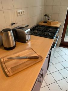 un mostrador de cocina con un cuchillo en una tabla de cortar en Stilvolle Wohnung mit Balkon & Parkplätzen, en Bremen