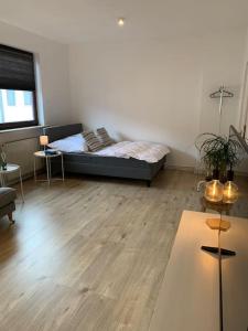 a living room with a bed and a wooden floor at Stilvolle Wohnung mit Balkon & Parkplätzen in Bremen