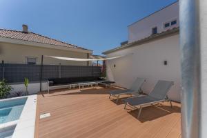 een patio met 2 stoelen en een zwembad bij Bernie apartments with a pool in Zadar