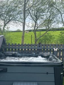 a hot tub with water in it next to a fence at Little Bunny Retreat in Bradmore