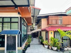 a walkway between two buildings with plants in pots at Chubby 5 Room 3 in Bang O