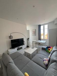 a living room with a couch and a tv at 3P Monaco avec parking in Saint-Antoine
