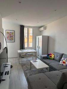 a living room with a couch and a table at 3P Monaco avec parking in Saint-Antoine
