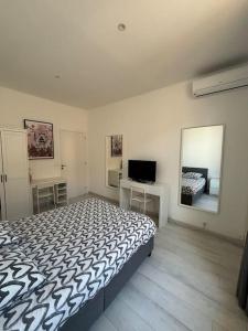 - une chambre avec un lit et une télévision dans l'établissement Monaco Cosy 3 pièces, à Saint-Antoine