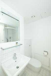 a white bathroom with a sink and a toilet at Stephen Hawking Building Gonville and Caius College in Cambridge