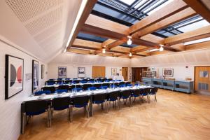 una sala de conferencias con una mesa larga y sillas en Stephen Hawking Building Gonville and Caius College en Cambridge