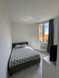 a white bedroom with a bed and a window at Monaco Cosy 3 pièces in Saint-Antoine