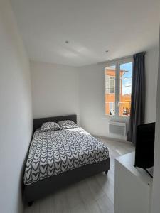 a white bedroom with a bed and a window at 3P Monaco avec parking in Saint-Antoine