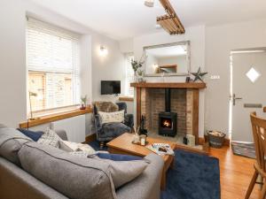 a living room with a couch and a fireplace at Larl Cottage in Barnard Castle