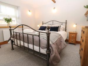 - une chambre avec un lit noir et des oreillers blancs dans l'établissement Larl Cottage, à Barnard Castle