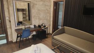 una camera con divano, tavolo e specchio di Domus Aquae Rooms & Wellness a Genova