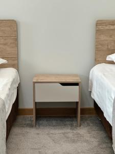 a wooden table in a room with two beds at PORT INN Hotel in Astana
