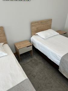 1 dormitorio con 2 camas y mesita de noche entre ellas en PORT INN Hotel en Astaná