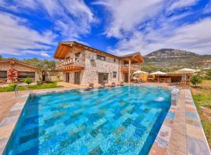 a villa with a swimming pool and a house at Sedir Taş Evleri in Kalkan