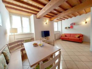 ein Wohnzimmer mit einem Tisch und einem roten Sofa in der Unterkunft Vista sul Lago di Endine in Ranzanico