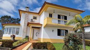 a home with a yellow and white house at Villa Familia Dehoux in Camacha