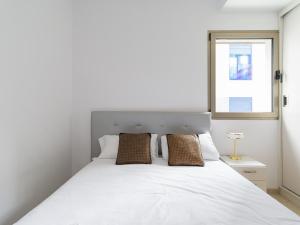 a bedroom with a white bed and a window at Montevideo By CanariasGetaway in Guanarteme