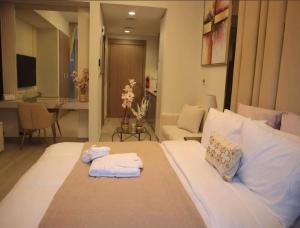 Una cama blanca grande en una habitación con toallas. en Business Bay Stylish Apartment In Dubai en Dubái