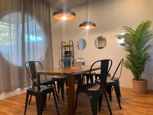 a dining room with a wooden table and black chairs at Mini-ME Home, A Cozy Entire House in Old City in Chiang Mai