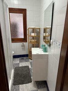 Baño blanco con lavabo y espejo en Casa Victoria, en Bargas