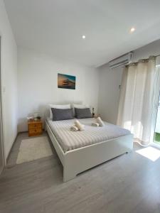a bedroom with a large white bed in a room at Apartments Sun & Sea in Dugi Rat