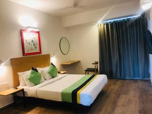 pokój hotelowy z dużym łóżkiem i oknem w obiekcie Tulip Grand w mieście Dżajpur