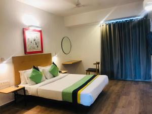 um quarto de hotel com uma cama grande e uma janela em Tulip Grand em Jaipur