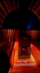 a fireplace in a room with a wooden floor at Bodos’ Shepards Hut in Durham