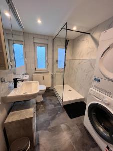 a bathroom with a sink and a washing machine at Ferien- und Monteurwohnungen Andrej in Eisenach