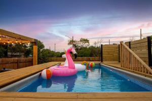 a swimming pool with a pink flamingo float in the water at Pool-MovieTheater KING BED & 5 minutes to Alamodome in San Antonio