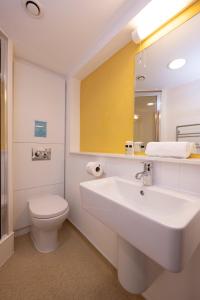 een badkamer met een wastafel, een toilet en een spiegel bij Harvey Court Gonville and Caius College in Cambridge