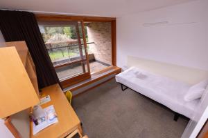ケンブリッジにあるHarvey Court Gonville and Caius Collegeのベッドと窓のある小さな部屋