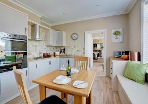 a kitchen and living room with a table and a couch at Sea Peeps in Hunstanton
