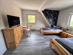 a room with a bedroom with a bed and a tv at Ferien- und Monteurwohnungen Andrej in Eisenach