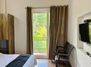 ビムタルにあるThe Lakehaven Cottageのベッドルーム1室(ベッド1台付)、窓、バルコニーが備わります。