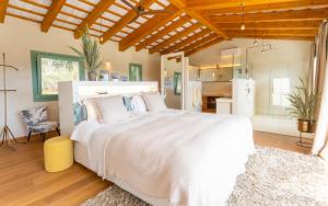 a bedroom with a large white bed and a kitchen at MAS CASA GRAN in Rupiá