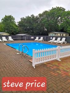 a white fence next to a swimming pool with chairs at Get aways in west wales in Llandysul