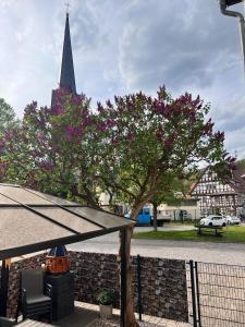a tree with pink flowers in front of a church at Ferien- und Monteurwohnungen Andrej in Eisenach
