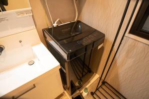 a microwave oven sitting on top of a table at 浅草禅心居201室 浅草駅徒歩15分 2024年4月ニューオープン 43平米丸貸し切り ダブルベット2台と畳敷き布団2組 家庭式用品設備完備 in Tokyo +35 photos