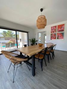 een eetkamer met een houten tafel en stoelen bij Cairnvillas - Villa Mar C38 Luxury Villa with Private Swimming Pool near Beach in Aljezur