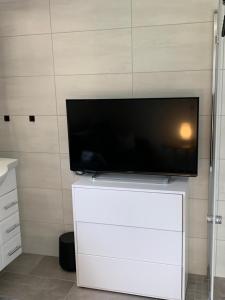 a flat screen tv sitting on top of a white cabinet at Ferienzimmer Balou in Weener