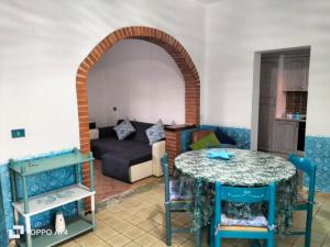 a living room with a table and a couch at Casa vacanze sa Cresiedda in Iglesias