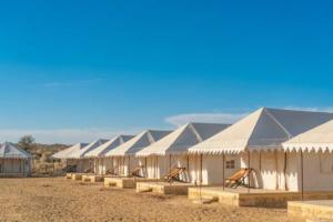eine Reihe weißer Zelte auf einem Feld in der Unterkunft Hostel Desert camp Sam in Jaisalmer