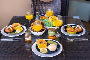 una mesa con platos de comida y vasos de jugo de naranja en Casa Julia, en Playa Paraiso