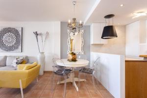 cocina y sala de estar con mesa y sofá amarillo en Casa Julia, en Playa Paraiso