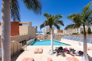 una piscina con palmeras y gente sentada en sillones en Casa Julia, en Playa Paraiso 36 fotos más