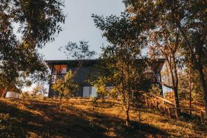 a house on a hill with trees in the foreground at Into The Wild Cabin in Gonçalves